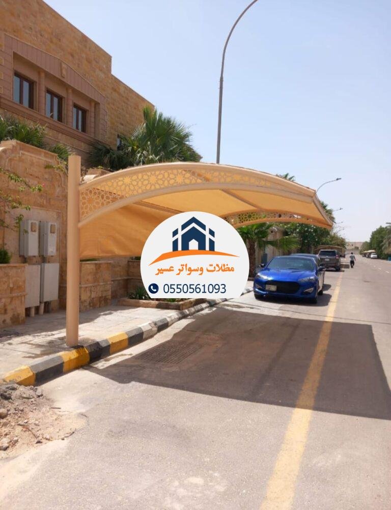 مظلة قماشية ملونة توفر الظل والحماية من الشمس في الفناء الخارجي.